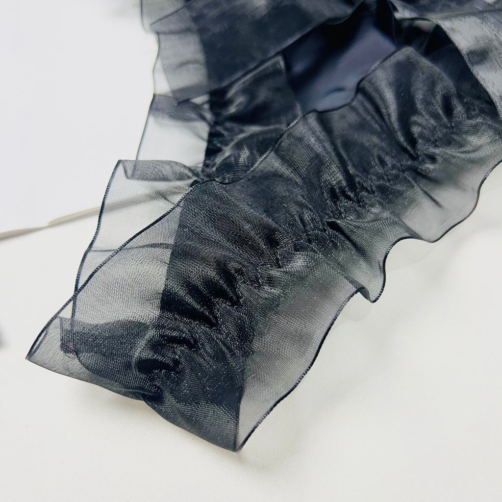 black pearl bow thong lingerie fabric close up texture detail