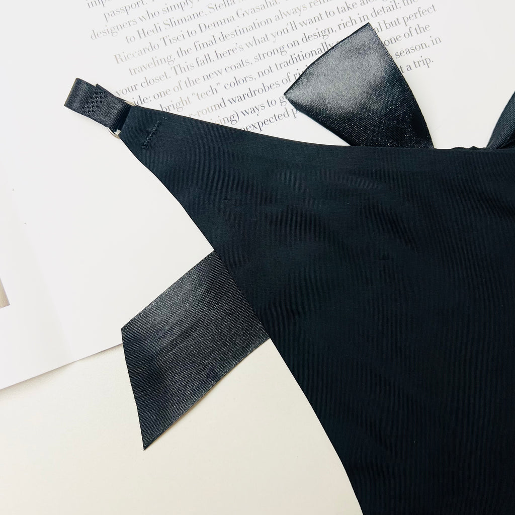 black silk bow thong lingerie bow detail close up fabric texture