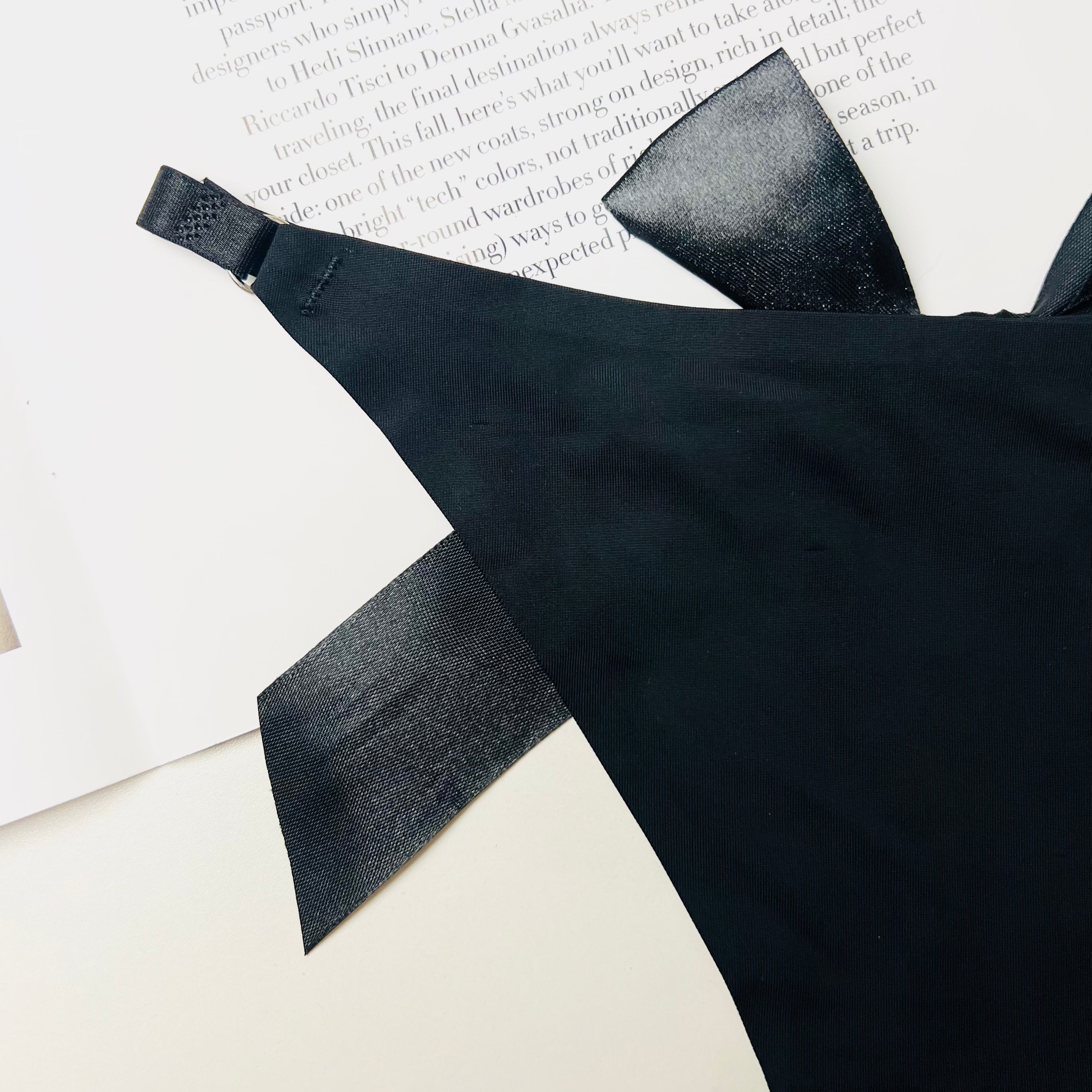 black silk bow thong lingerie bow detail close up fabric texture