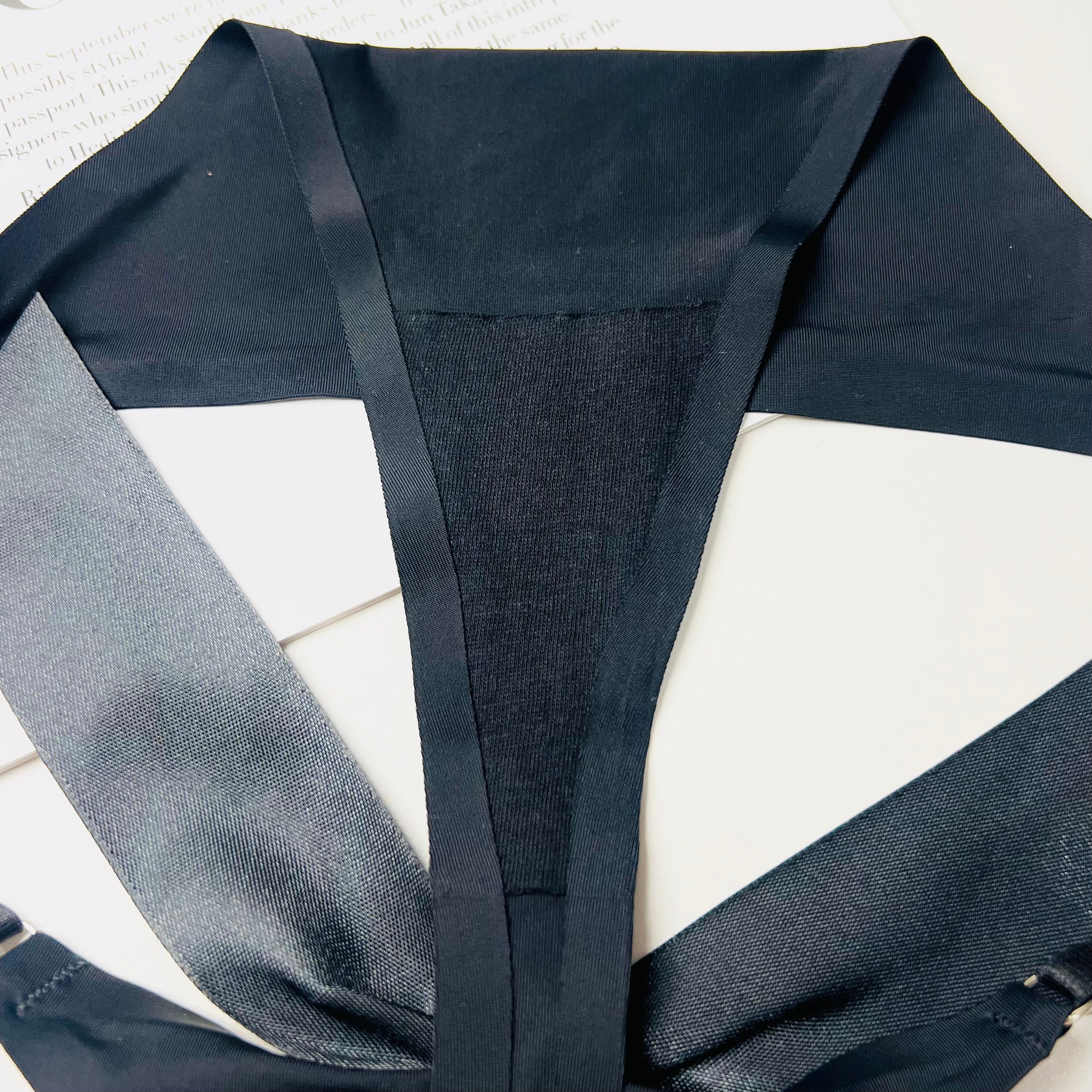 black silk bow thong lingerie fabric close up silk texture detail