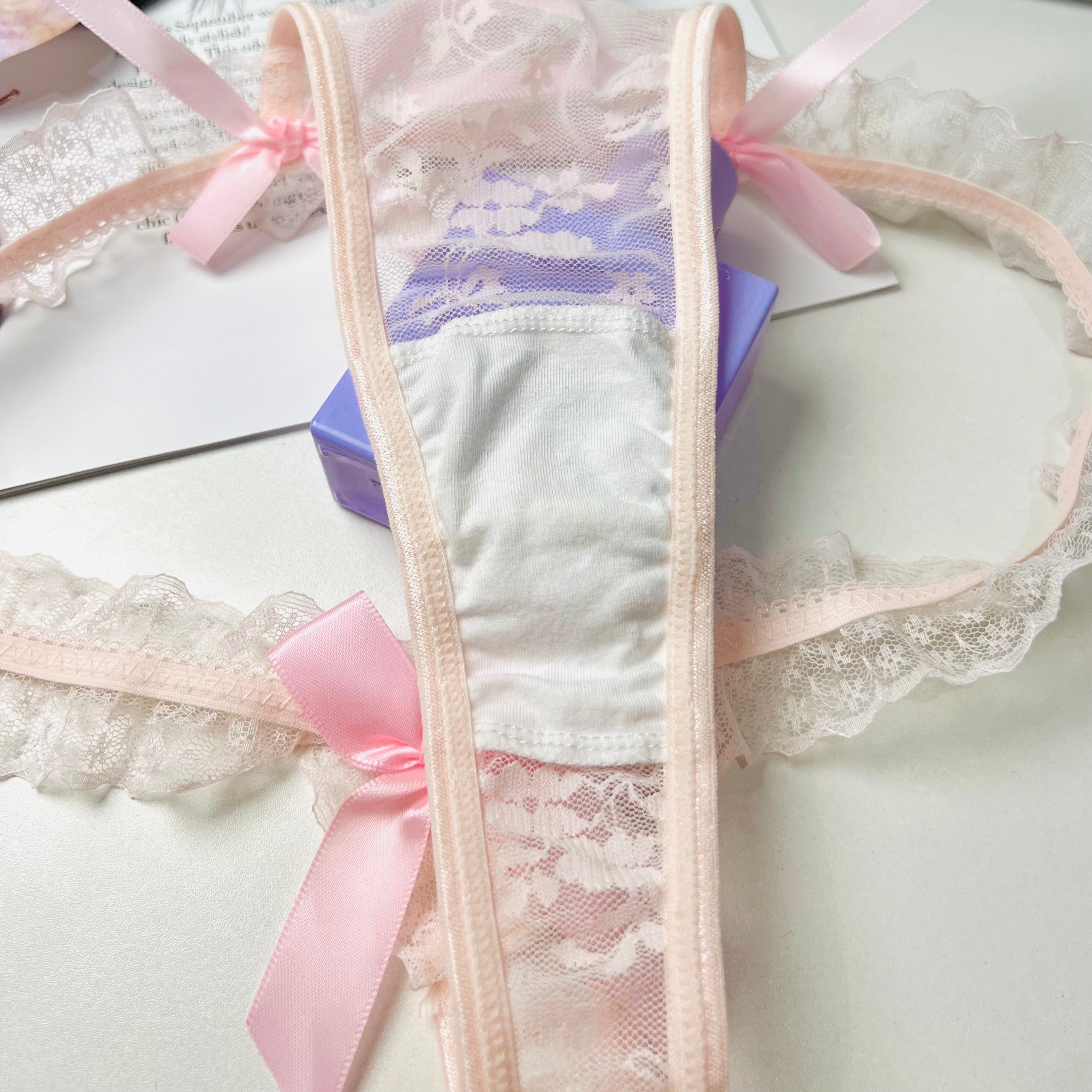 pink lace bow thong lingerie crotch detail close up fabric stitching