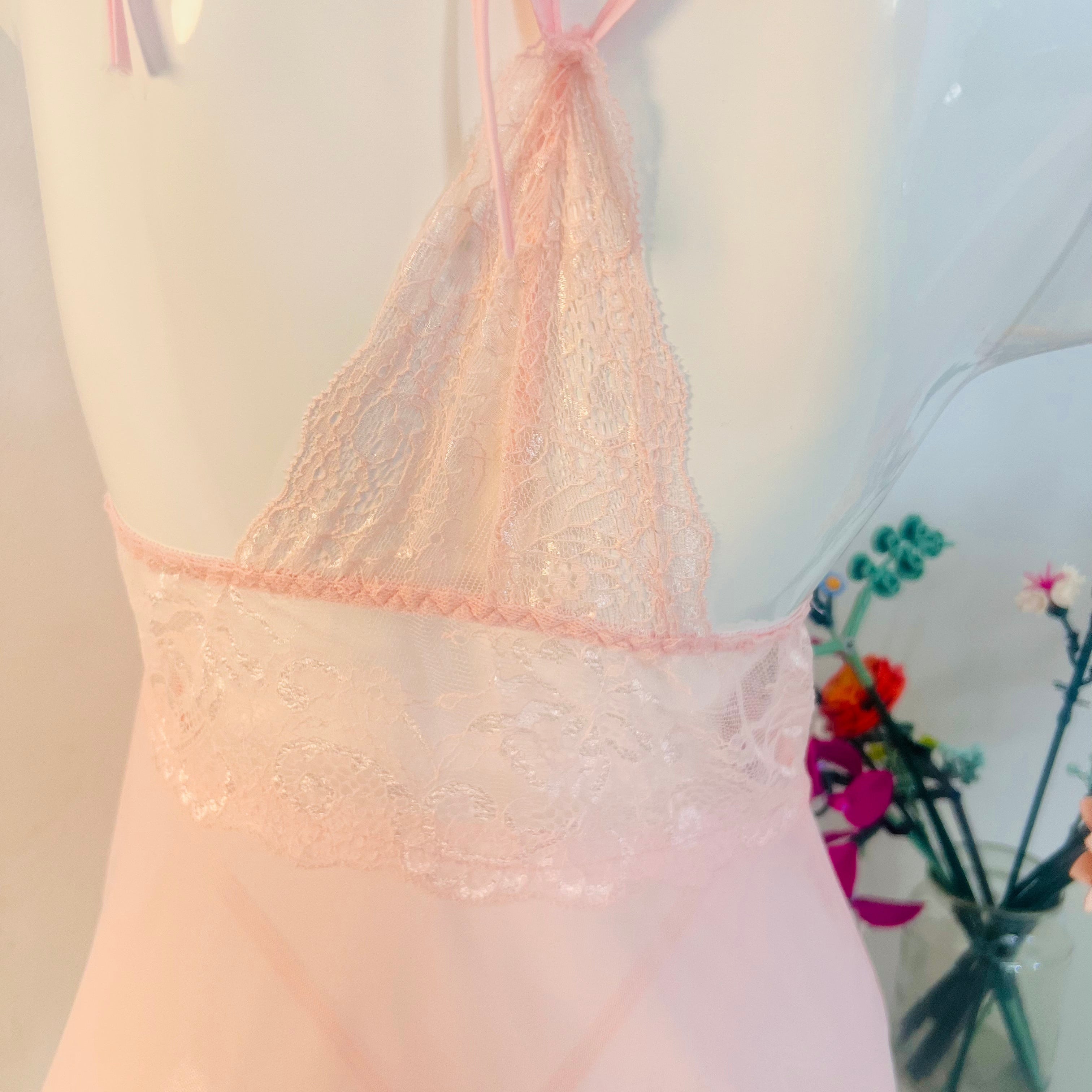 close up back design of pink lace sleep dress showing delicate strap detail