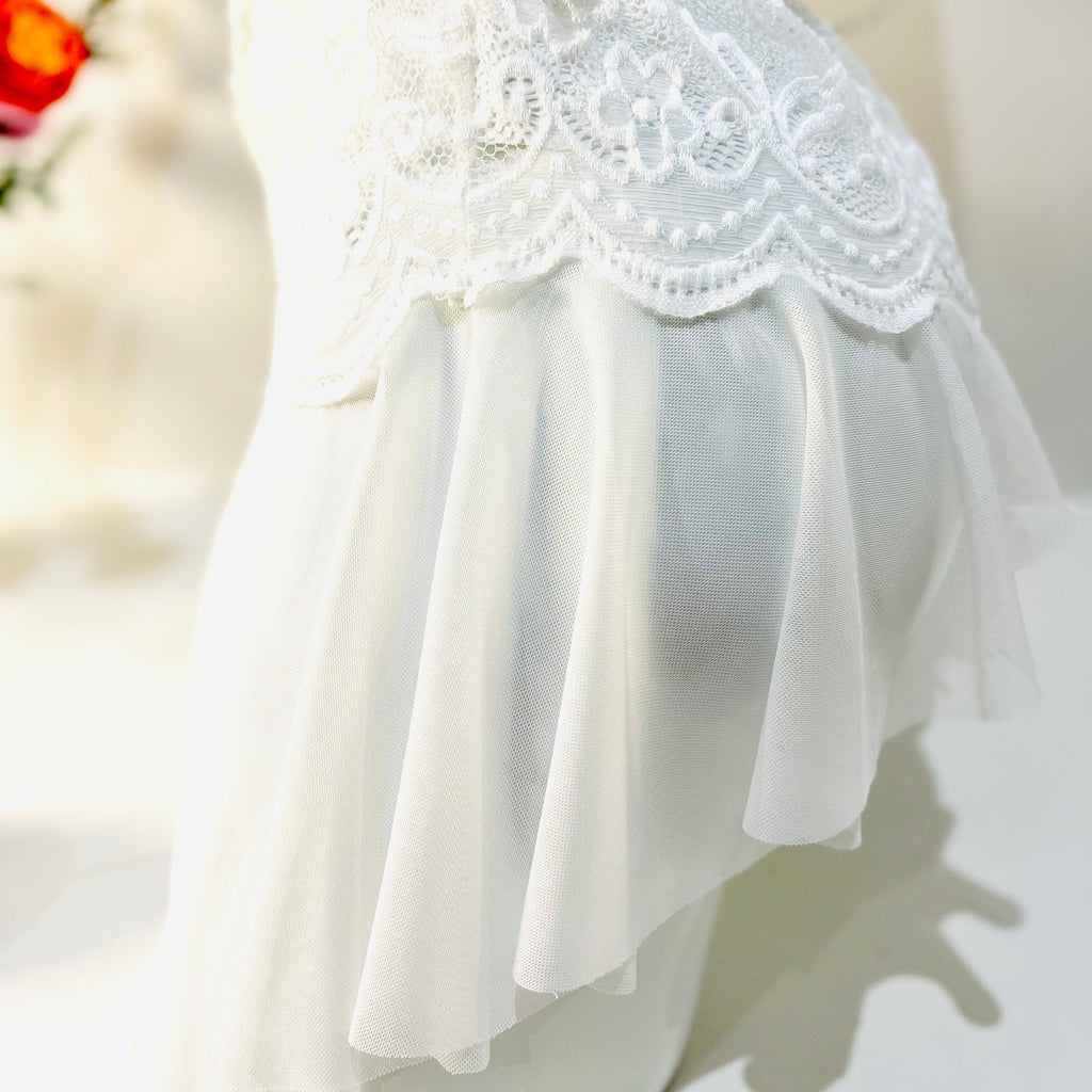 lace edge detail on white bodysuit showing soft finish and delicate pattern